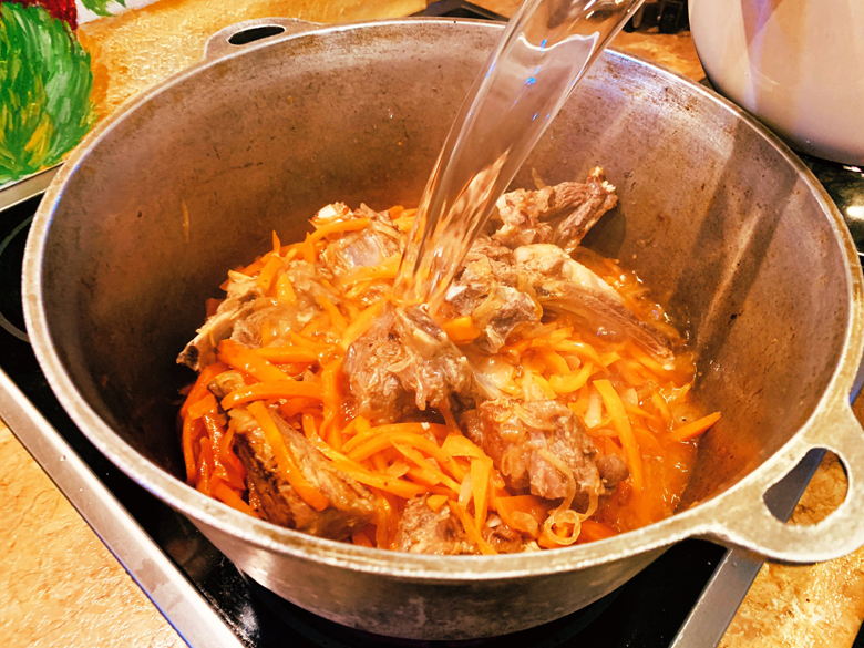 Мясо с луком и морковью в казане для рецепта тушеной капусты
