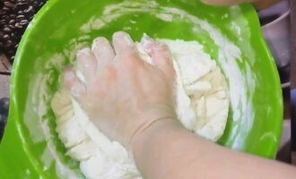 Затем частями введите в опару муку, яйца, подсолнечное масло и соль. Когда тесто станет плотным, начинайте вымешивать его руками.