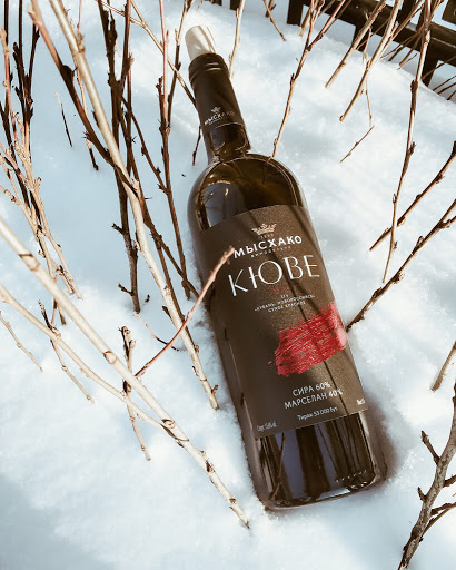 Бутылка красного Мысхако Кюве на снегу